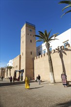 People walking outside medina walls, L'Horloge d'Essaouira, Essaouira, Morocco, north Africa,