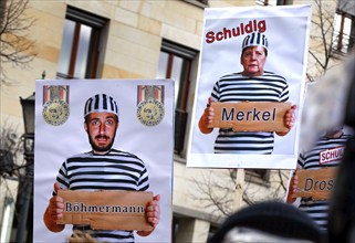 Posters show Chancellor Merkel and Jan Böhmermann in convict clothing. Once again, thousands of