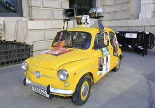 Small yellow SEAT car with megaphones and political posters, Madrid city centre, Spain, Europe