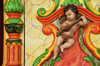 Wooden figure, colourfully painted, cherub at a carousel organ, fairground organ, historic