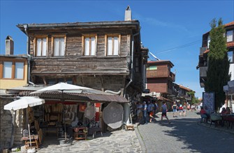 Street view with old wooden buildings, souvenirs and a lively street café on a sunny day, Black