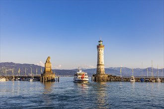 Bavarian Lion, an excursion boat and the lighthouse in the harbour, Lindau Island, Lindau, Lake