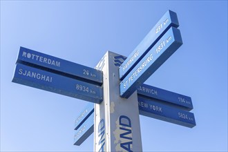 Signposts, cardinal points, to near and far destinations, on the beach of Hoek van Holland, low