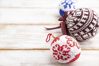 Christmas or New Year composition. Decorations, knitted balls, on a white wooden background. Side