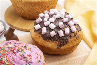 Homemade glazed and decorated easter pies with chocolate eggs and rabbits on a white concrete