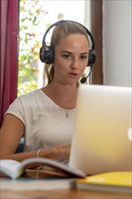 Young student learns at home, online, in conversation with other students