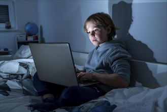 Boy, at home on the computer, laptop, in the children's room, playing a game