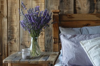 Lavender flowers (Lavendula) in a vase on a bedside table next to a bed, rustic, rural ambience, AI