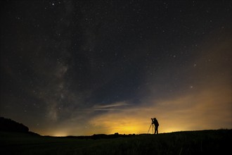 Photographer with tripod in a meadow with starry sky, Mindelheim, Unterallgäu, Bavaria, Germany,