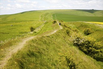 Two men walking along the ditch and embankment of the Wansdyke a Saxon defensive structure on All