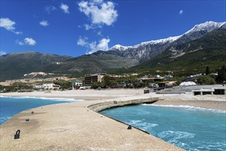 Tourist development construction building work view from Drymades beach to Mount Cika snow capped