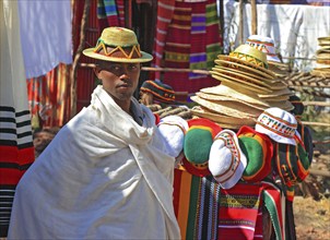 Trader with hat and shawl offers souvenirs, shawls and hats, Ethiopia, Africa