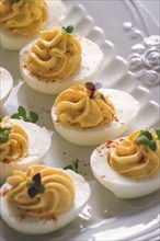 Boiled eggs stuffed with yolk with mayonnaise, on a white plate, selective focus, blurry, close-up,