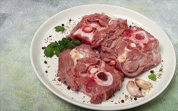 Raw steak, calf's neck on the bone, fresh meat, on a white plate, top view, no people