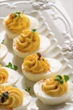 Boiled eggs stuffed with yolk with mayonnaise, on a white plate, selective focus, blurry, close-up,