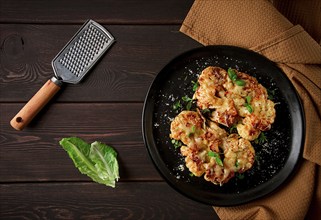 Steak, cauliflower, with cheese, spices, homemade, on a wooden table, dark background, close-up,