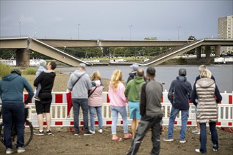 Passers-by look at the partially collapsed Carola Bridge from the Königsufer in Dresden, 11/09/2024