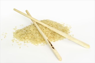 Rice (Oryza sativa), rice grains and chopsticks on a white background