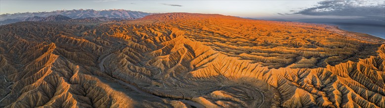 Panorama, river bed runs through a landscape of eroded hills at Lake Issyk Kul, badlands at