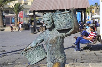 Fisherman statue sculpture in harbour at fishing village of Marsaxlokk, Malta, Europe