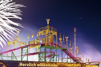 Cranger Kirmes with colourfully illuminated fairground rides and the Ferris wheel at night, Herne,