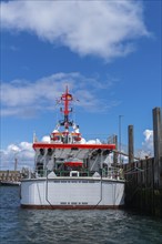 DGzRS rescue cruiser Hermann Marwede with dinghy in the harbour, stern view, Helgoland island, blue