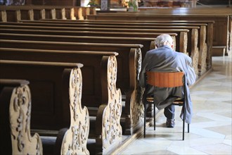 Old grey-haired man as the only churchgoer, interior of the Cistercian Abbey Church Fürstenfeld in