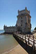 Historic stone tower with bridge over water in sunny weather, Torre de Belém, World Heritage Site,