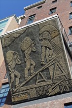 Harbour workers loading sacks of grain, historical relief on the office building Speicher Dock 13,