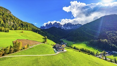 Farm and alpine meadows, in the background the peaks of the Geisler group, drone shot, Sankt