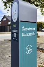 Public e-charging station with inscription "Ökostrom Tankstelle für E-Autos Elektro-Autos an