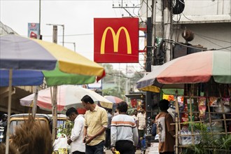 People walks by a McDonald's sign on October 26, 2024 in Guwahati, India. McDonald's recent food