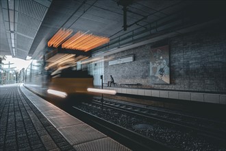 An underground railway moves through a modern, urban station with traces of light, Weinsteige,