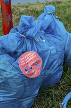 The Rhine near Düsseldorf, sacks of rubbish collected in the Rhine meadows and waiting to be taken