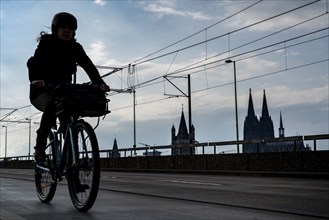 Cycling in the city, cyclist on the Deutzer Bridge in Cologne, Cologne Cathedral, cycle path, North