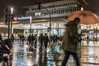 Passers-by at a pedestrian crossing, at the main railway station, rainy weather, city centre, in