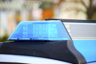 Symbolic image: Close-up of a police car with flashing blue lights