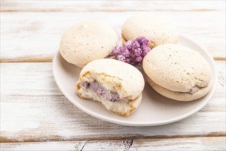 Meringues cakes on a white wooden background. Side view, close up