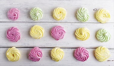 Set of colored meringues on white wooden background. top view, flat lay. geometric pattern