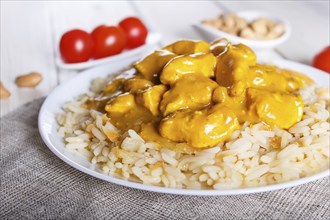 Rice with chicken curry sauce with cashew on white wooden background. selective focus, close up