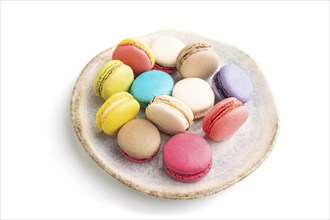 Multicolored macaroons on ceramic plate isolated on white background. side view, still life, close