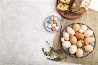 Homemade easter pie with raisins and eggs on plate on a gray concrete background and linen textile.