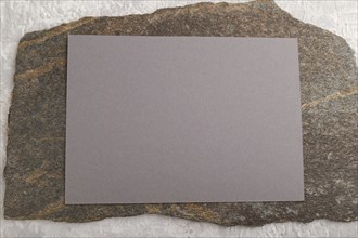 Gray paper business card, mockup with natural stone on gray concrete background. Blank, flat lay,