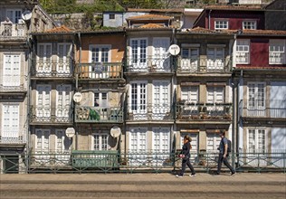 Front facades of narrow houses in the historic center near the Douro river in Porto, Portugal,