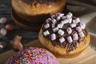 Homemade glazed and decorated easter pies with chocolate eggs and rabbits on a gray wooden