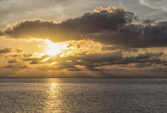 Beautiful sunset over the sea with the sun rays through the clouds, Malaysia, Asia