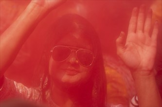 A girl dancing in the beat of music as she celebrate Holi on a street, the Hindu spring festival of