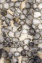 Dressed stone flint wall stonework facing flushwork exterior of church of Saint John, Saxmundham,