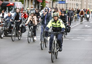 A policewoman from the Berlin bicycle squadron accompanies the bike parade demonstration, Berlin,