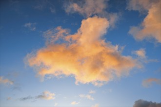 Orange spring clouds adorn the blue morning sky at sunrise